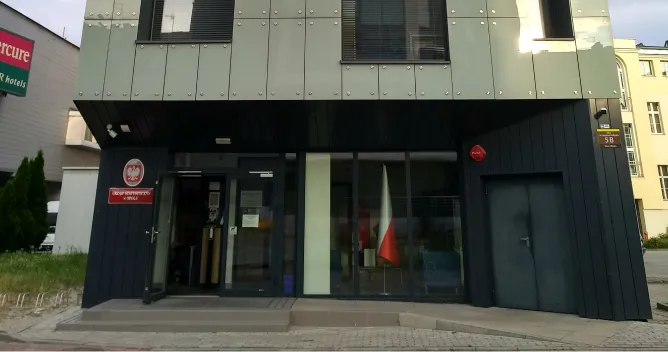 : Budynek – siedziba Urzędu Statystycznego w Opolu. Nowoczesny 3-piętrowy budynek z płaskim dachem w kolorze szarym i czarnym.